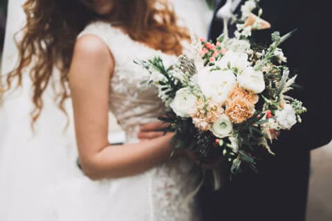 An image of a couple embracing on their wedding day to represent marriage on the journey of life